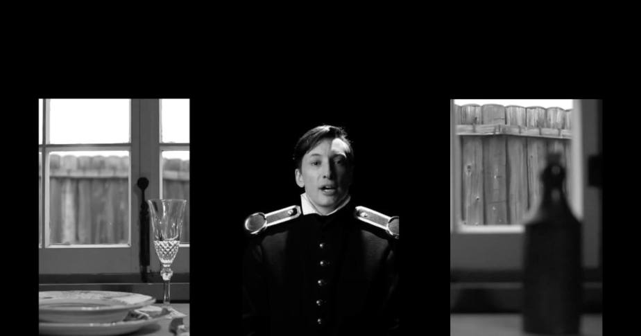 Un homme en uniforme se trouve devant une table, symbolisant l'autorité et le sérieux dans un cadre formel.